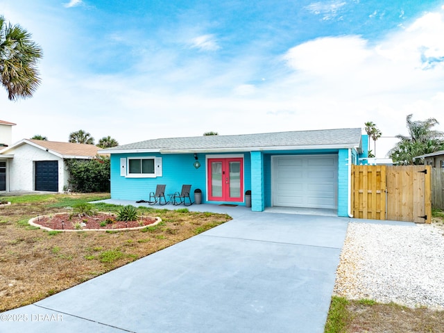 8 Tarpon Ave, Ormond Beach, FL 32176 - ranch-style home with french doors, a garage, concrete driveway, and fence