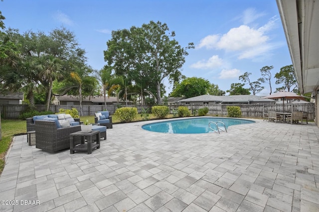 view of swimming pool with an outdoor living space, a patio, and a fenced backyard