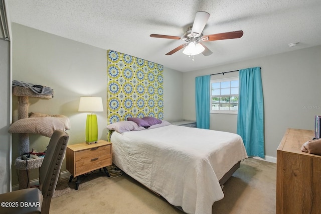 bedroom with light carpet, ceiling fan, a textured ceiling, and baseboards