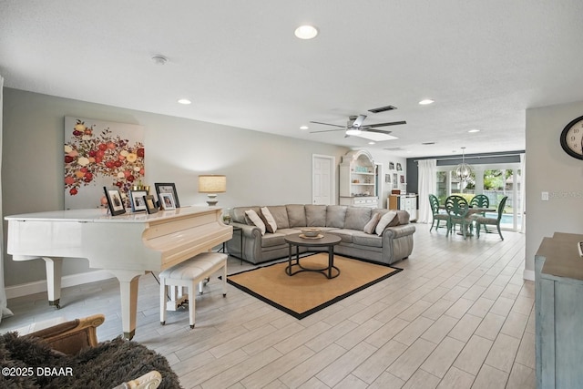 living area featuring a ceiling fan, recessed lighting, baseboards, and light wood-type flooring