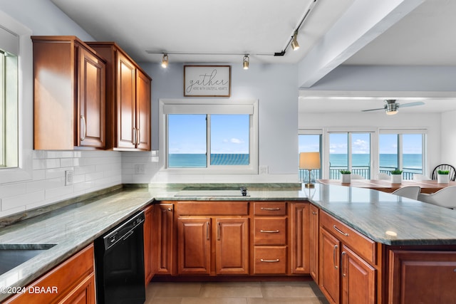 kitchen featuring a water view, kitchen peninsula, black appliances, light tile patterned floors, and light stone countertops