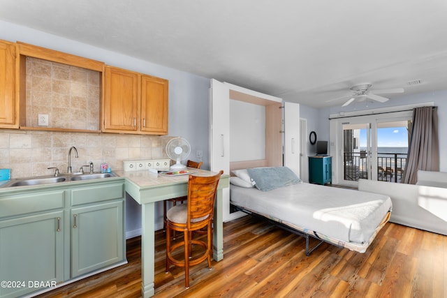 kitchen featuring dark wood-type flooring, sink, ceiling fan, and backsplash