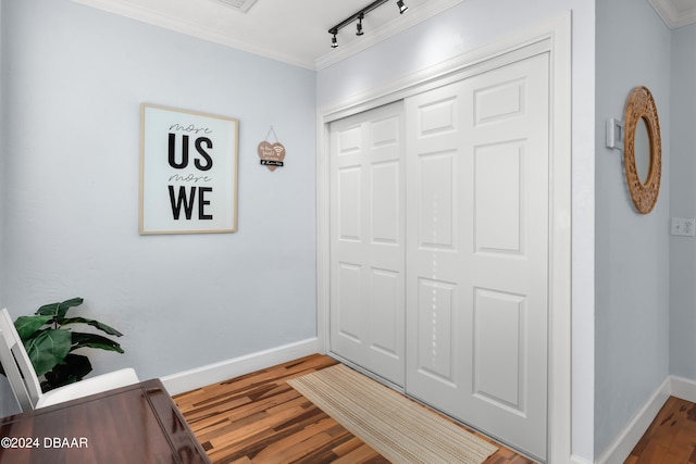 foyer with ornamental molding, track lighting, and hardwood / wood-style flooring