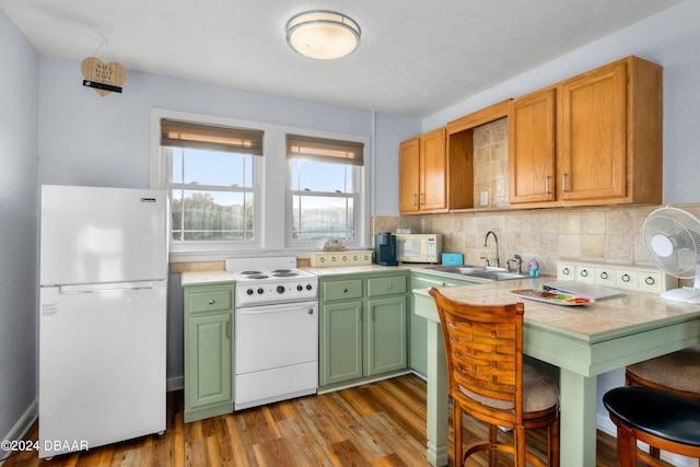 kitchen featuring tasteful backsplash, dark wood-type flooring, sink, and white appliances