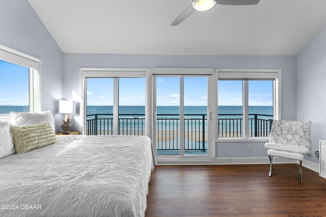 bedroom featuring dark wood-type flooring, multiple windows, and a water view