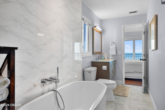 bathroom featuring a wealth of natural light, a water view, toilet, and vanity