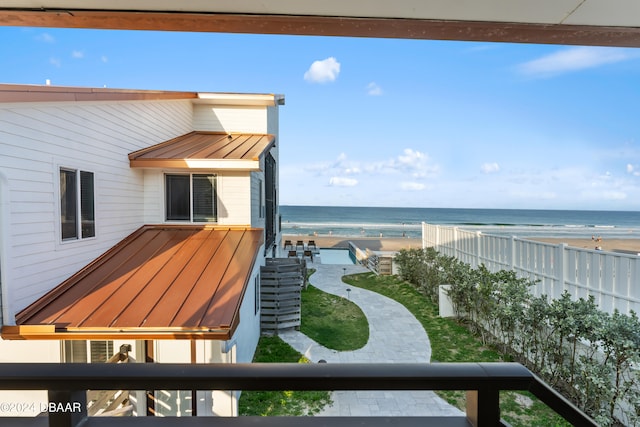 exterior space featuring a beach view, a water view, and a patio area