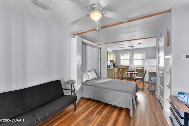 bedroom featuring ceiling fan, hardwood / wood-style flooring, and white fridge