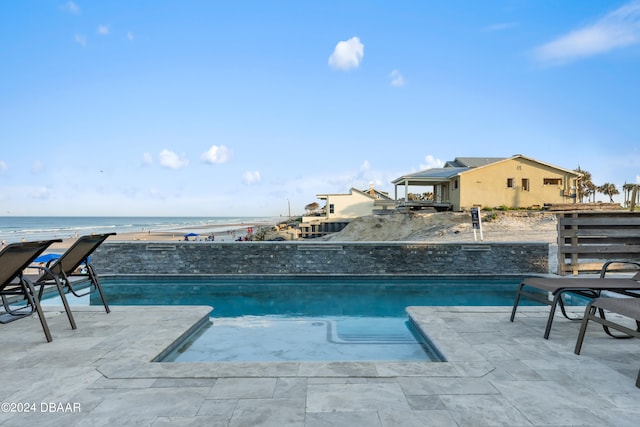 view of swimming pool with a water view and a patio