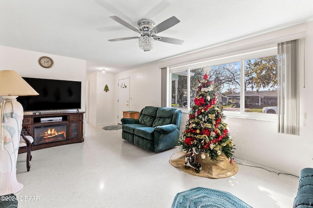 living room featuring ceiling fan and a textured ceiling