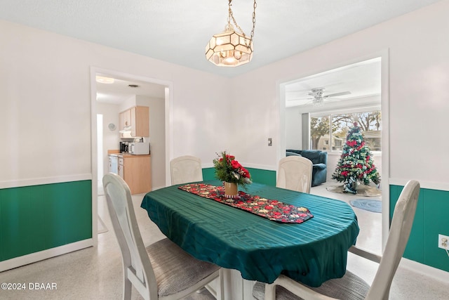 dining area featuring ceiling fan with notable chandelier