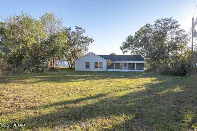 view of front facade featuring a sunroom and a front lawn