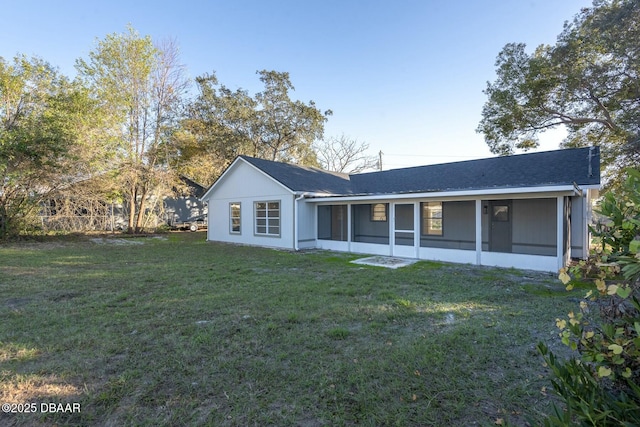 rear view of property featuring a sunroom and a yard