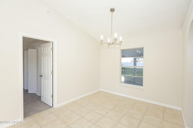 tiled spare room with a chandelier