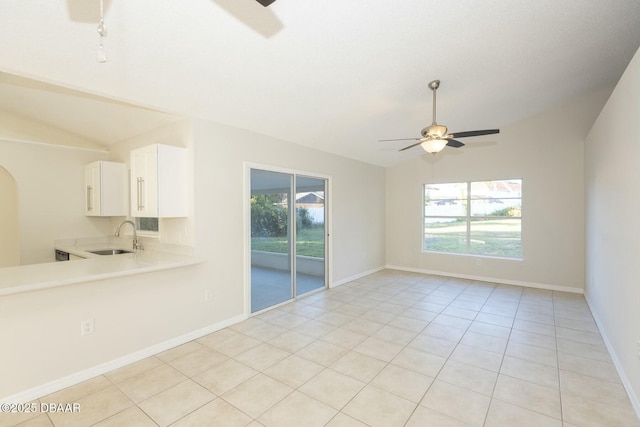 unfurnished room featuring ceiling fan, light tile patterned flooring, lofted ceiling, and sink