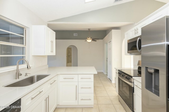 kitchen with sink, kitchen peninsula, vaulted ceiling, white cabinetry, and stainless steel appliances