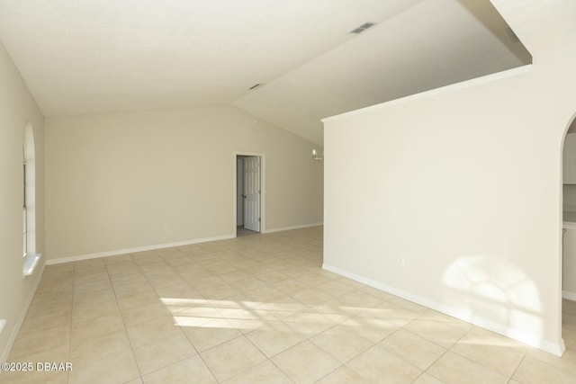 tiled spare room with vaulted ceiling