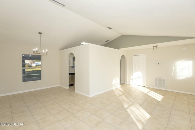 tiled empty room with a chandelier and vaulted ceiling