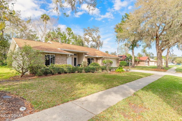 ranch-style home featuring a garage, brick siding, and a front yard