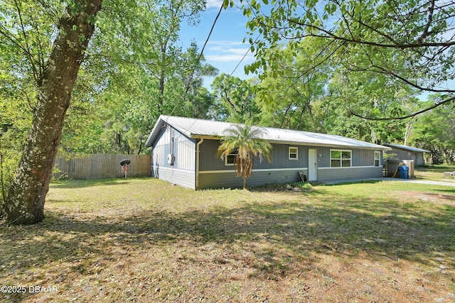 view of front of house featuring a front yard, fence, and metal roof