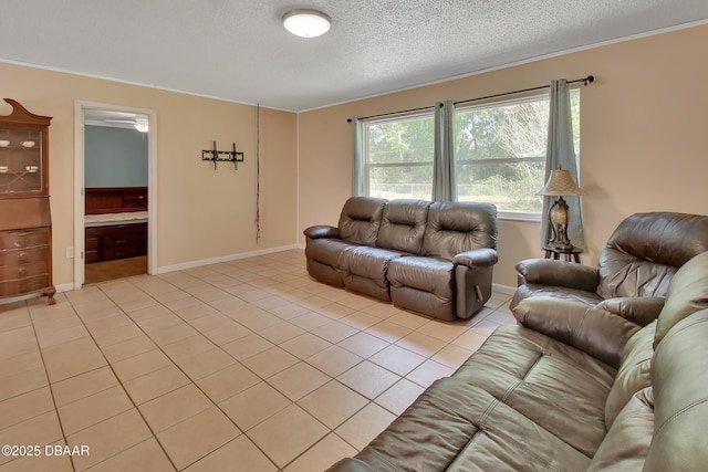 living area with light tile patterned floors, baseboards, ceiling fan, and a textured ceiling
