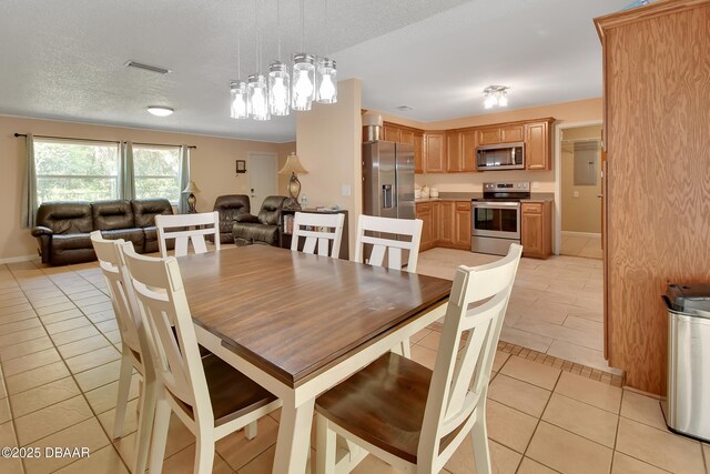 dining space featuring a textured ceiling, visible vents, and light tile patterned floors
