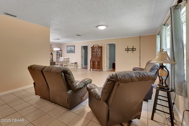living area featuring light tile patterned floors, a textured ceiling, visible vents, baseboards, and a notable chandelier