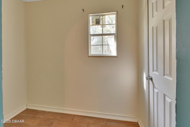 spare room with light wood-style flooring and baseboards