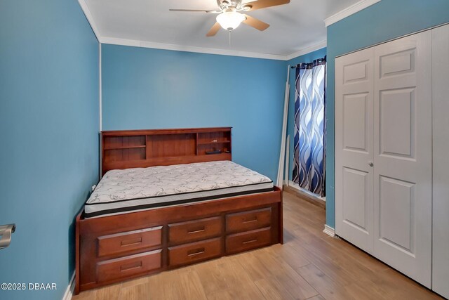 bedroom with a closet, ceiling fan, crown molding, and light wood finished floors
