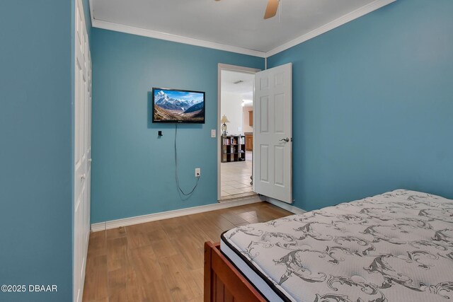 bedroom featuring baseboards, wood finished floors, and ornamental molding