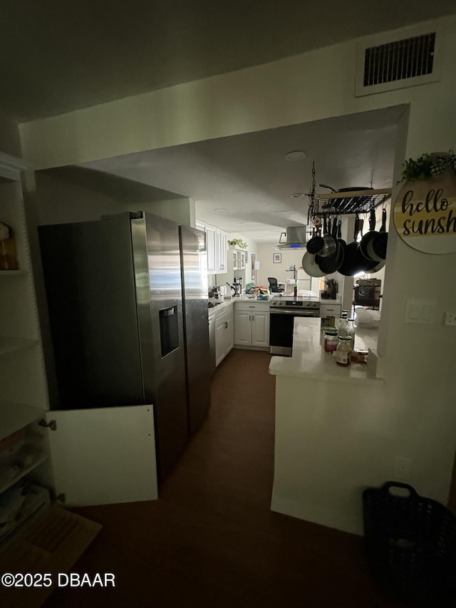 kitchen featuring appliances with stainless steel finishes, white cabinets, and kitchen peninsula