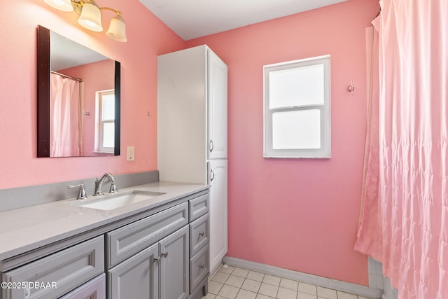 full bath featuring baseboards, vanity, and tile patterned flooring