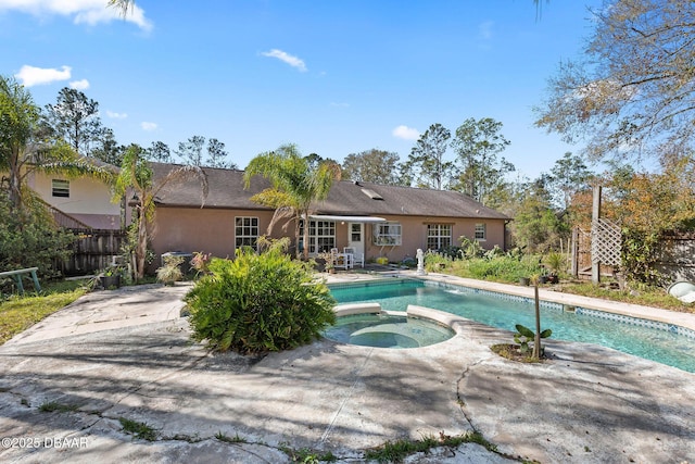 view of swimming pool with a patio, a pool with connected hot tub, and fence