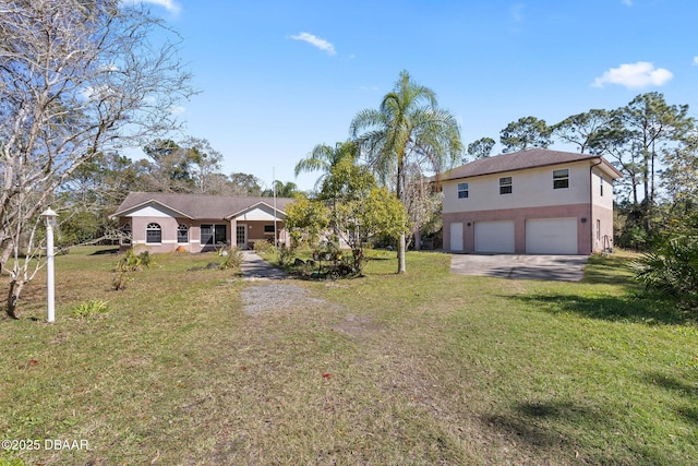 view of front of house featuring a front lawn, an attached garage, driveway, and stucco siding