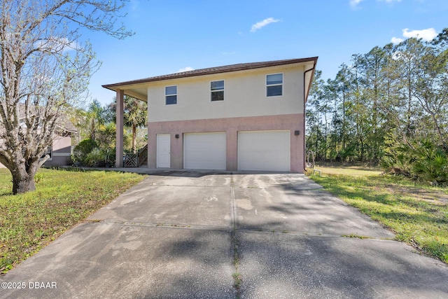 view of front of house featuring concrete driveway, a garage, a front yard, and stucco siding