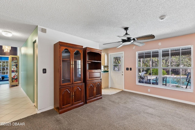 interior space featuring light tile patterned floors, light carpet, a healthy amount of sunlight, and ceiling fan