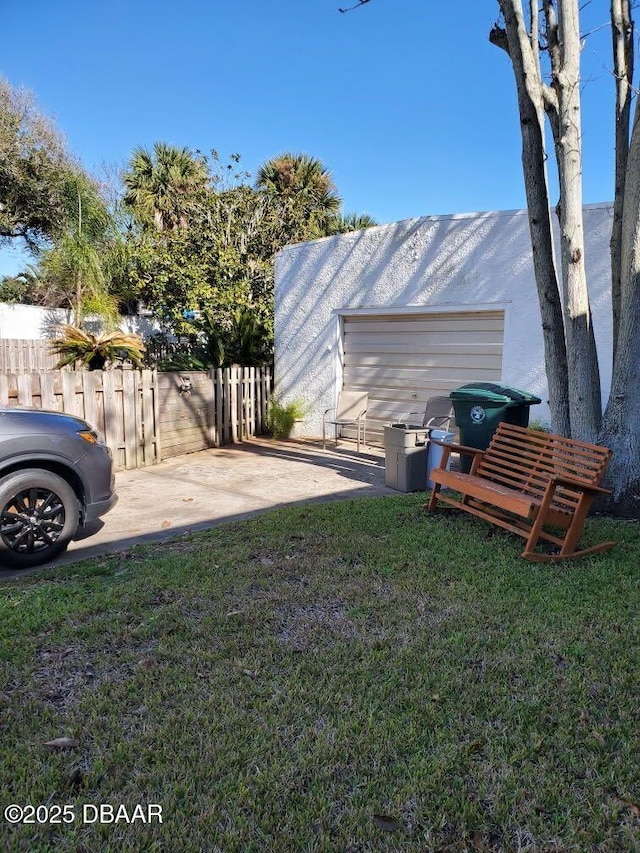 view of yard with a garage, fence, and a patio