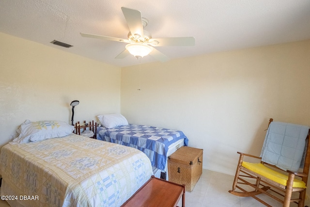 bedroom with ceiling fan and a textured ceiling