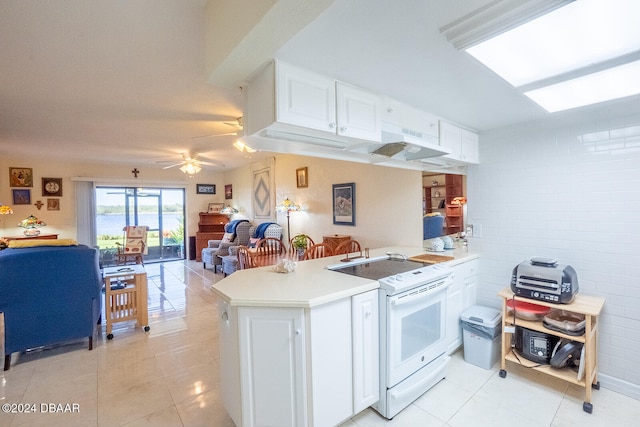 kitchen featuring kitchen peninsula, ceiling fan, light tile patterned floors, electric range, and white cabinetry