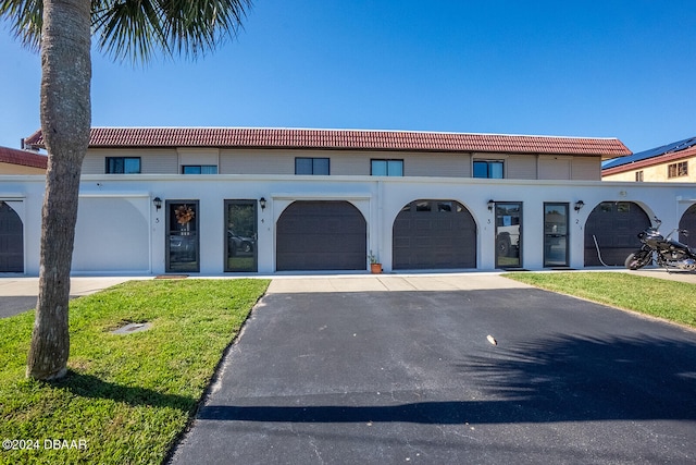 view of front of property featuring a front lawn and a garage