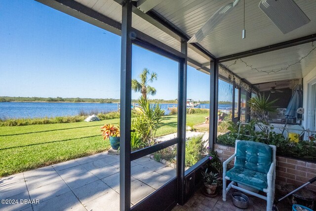 sunroom / solarium with a water view and ceiling fan