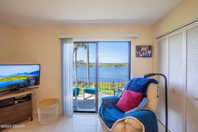 living area featuring a water view and light tile patterned floors