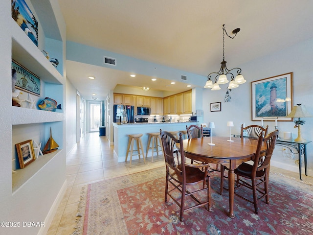 dining room featuring built in shelves, light tile patterned floors, and a chandelier