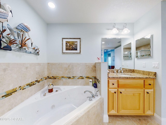 bathroom with tile patterned flooring, a relaxing tiled tub, and vanity