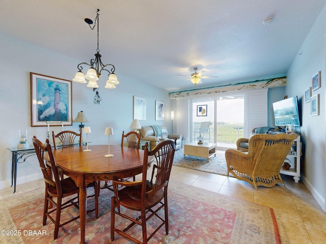 tiled dining space featuring ceiling fan with notable chandelier