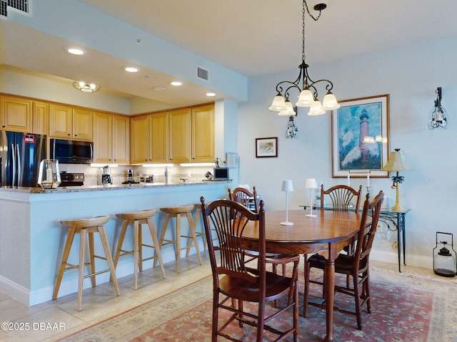 tiled dining area with a chandelier