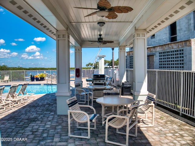 view of patio with ceiling fan, a grill, a water view, and a community pool