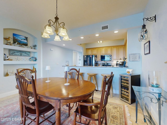 dining space featuring built in features, beverage cooler, and an inviting chandelier