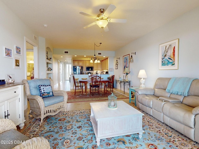 living room with light tile patterned flooring and ceiling fan with notable chandelier