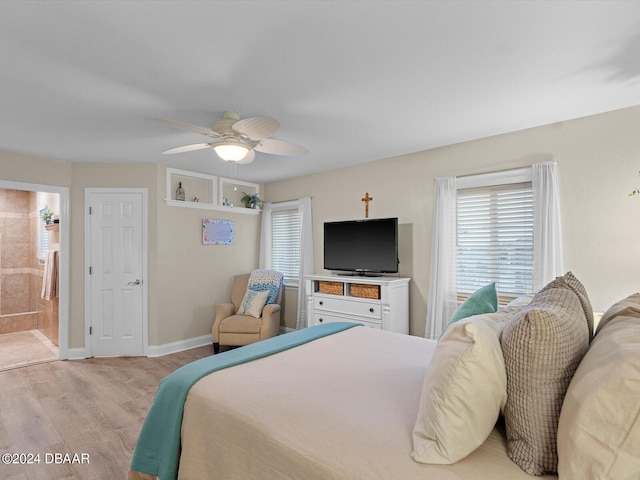 bedroom with light hardwood / wood-style floors, ceiling fan, and connected bathroom